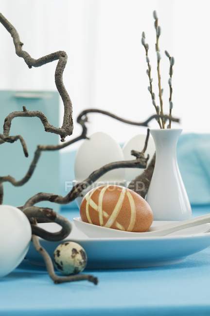 Крупный план украшения пасхального стола яйцами и ивой из штопора — стоковое фото
