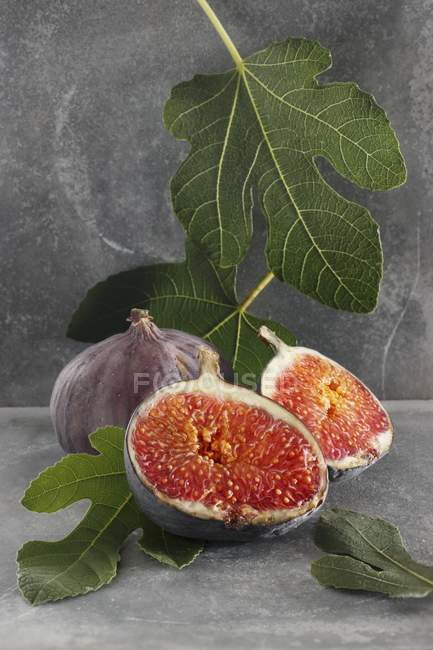 Figues fraîches et feuilles de figuier — Photo de stock