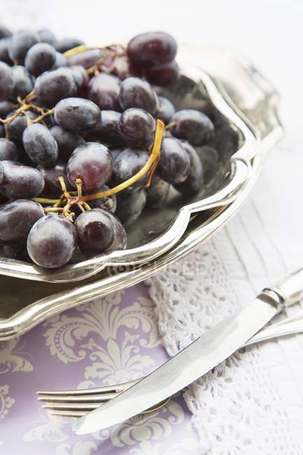 Raisins rouges dans un plat argenté — Photo de stock
