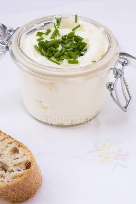 Quark with chives in a clip-top jar and a chunk of baguette — Stock Photo