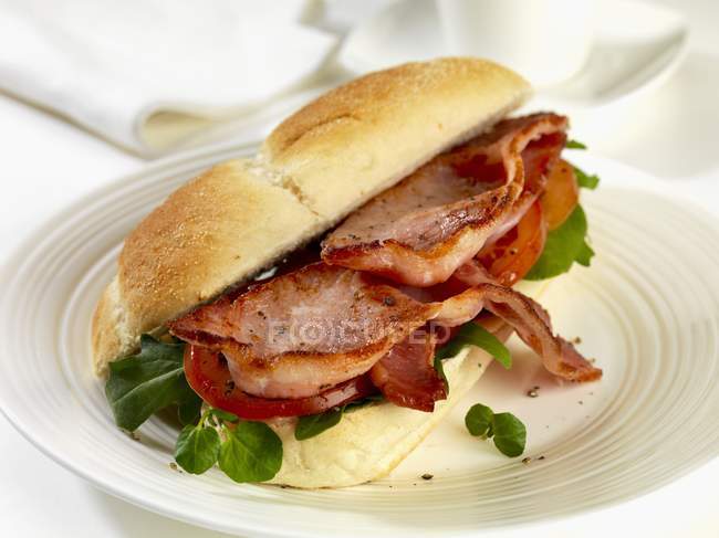 Bread roll filled with bacon — Stock Photo