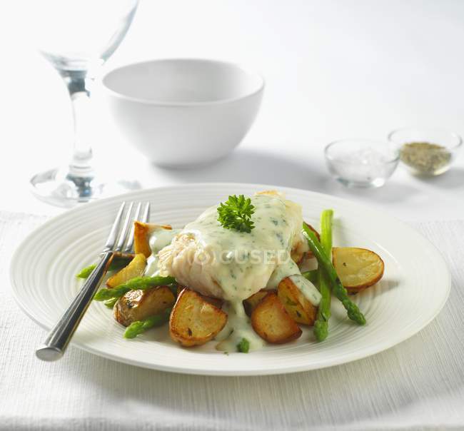 Cod in parsley sauce with fried potatoes — Stock Photo