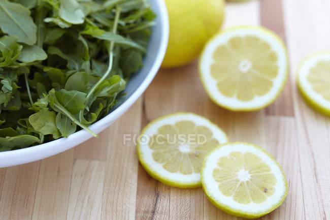 Rúcula fresca y limón en rodajas - foto de stock