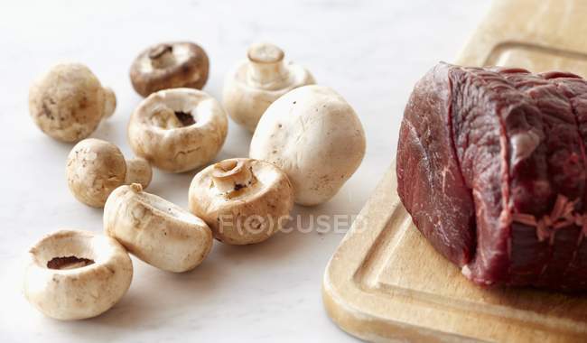 Сырая говядина с сырыми грибами — стоковое фото