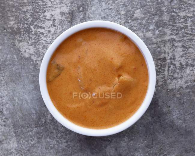 Vue du dessus de la sauce au curry dans un bol blanc sur la surface de la pierre — Photo de stock