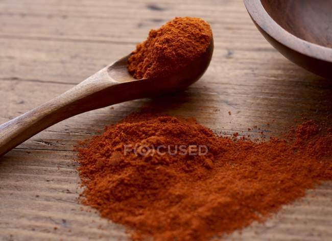Paprika in heap with wooden spoon — Stock Photo