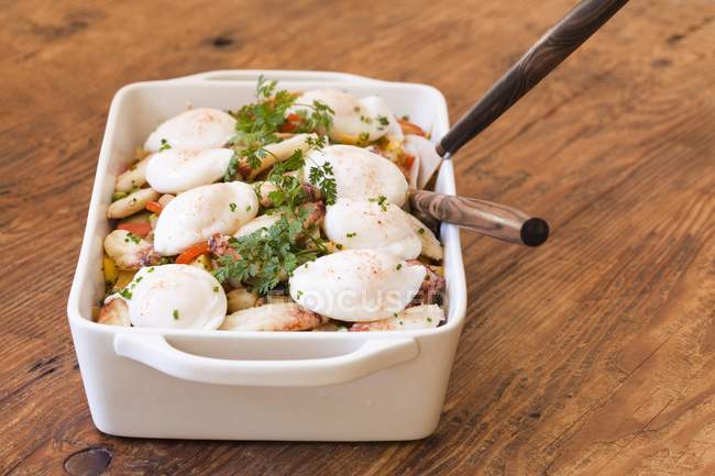 Œufs pochés sur homard cuit à la vapeur, poivrons et pommes de terre dans un plat blanc sur une surface en bois — Photo de stock