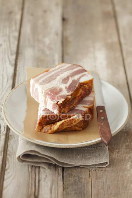 Pieces of Smoked bacon on plate — Stock Photo