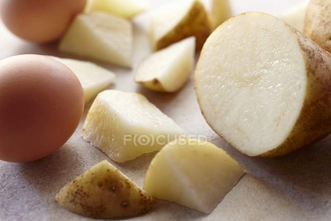 Свежий нарезанный картофель и сырые яйца — стоковое фото