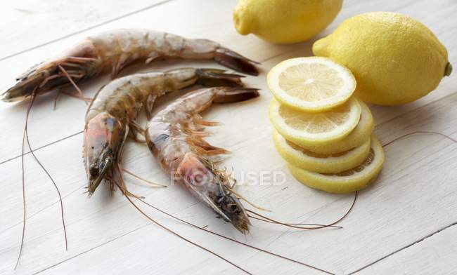 Crevettes crues et tranches de citron — Photo de stock