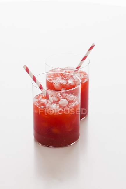 Vista close-up de bebidas de morango em copos com palhas — Fotografia de Stock
