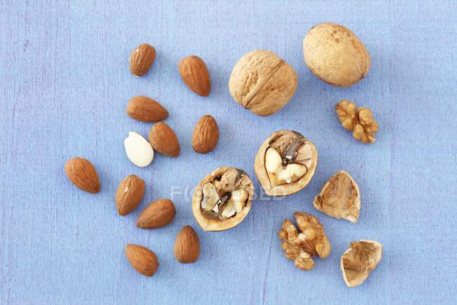 Walnuts and almonds on blue — Stock Photo
