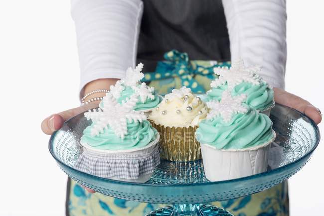 Mãos femininas segurando bandeja de cupcakes — Fotografia de Stock