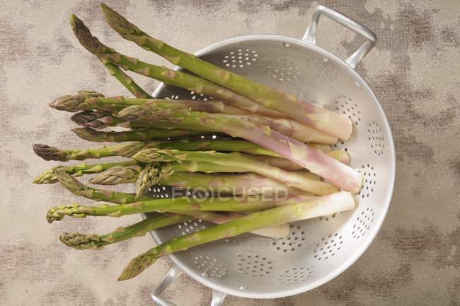 Green asparagus in colander — Stock Photo