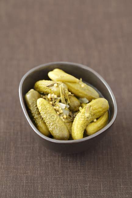 Pickled gherkins with curry flavourings in bowl — Stock Photo