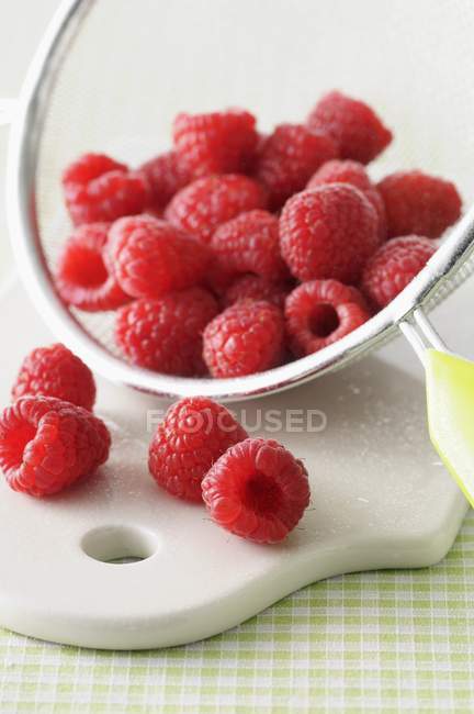 Fresh raspberries in sieve — Stock Photo