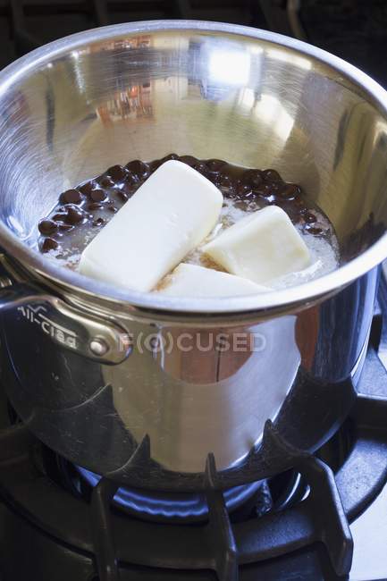Vue rapprochée de la fusion du beurre et des pépites de chocolat en pot sur le poêle — Photo de stock