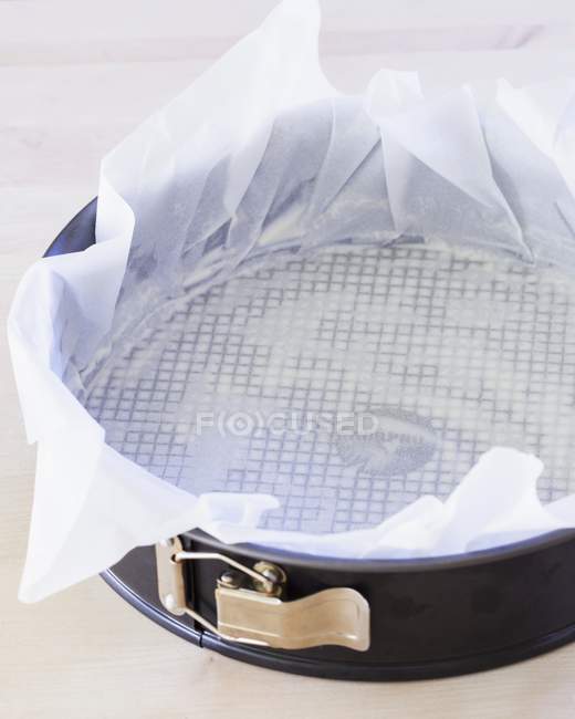Closeup view of a springform pan lined with parchment paper — Stock Photo