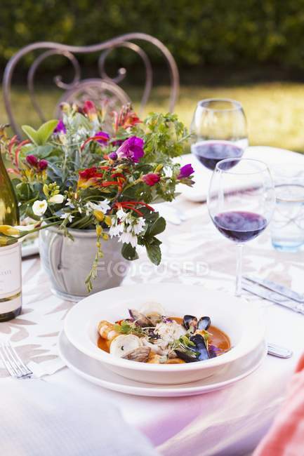 Mesa ao ar livre com marisco misto em caldo de tomate com ervas — Fotografia de Stock