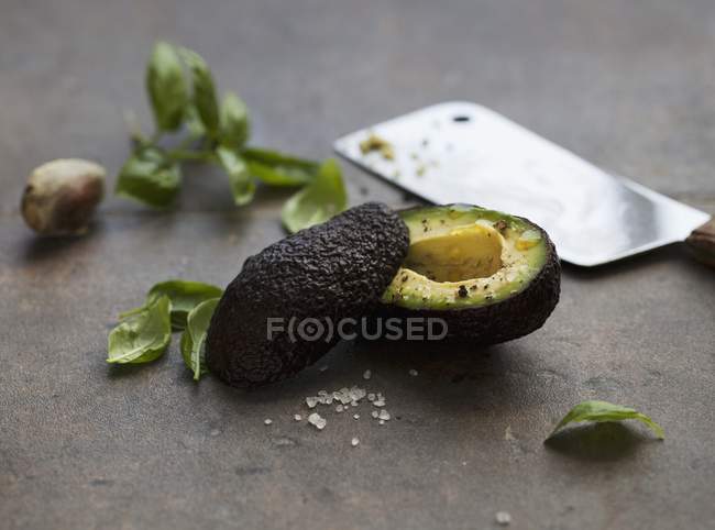 Halved avocado with fresh basil — Stock Photo