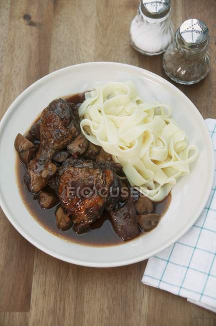 Chicken braised with wine and tagliatelle pasta — Stock Photo