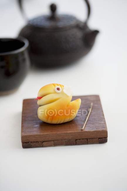 Vista da vicino del serpente Wagashi su tavola di legno con teiera — Foto stock