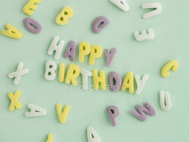 Close-up vista de letras doces soletrando feliz aniversário — Fotografia de Stock