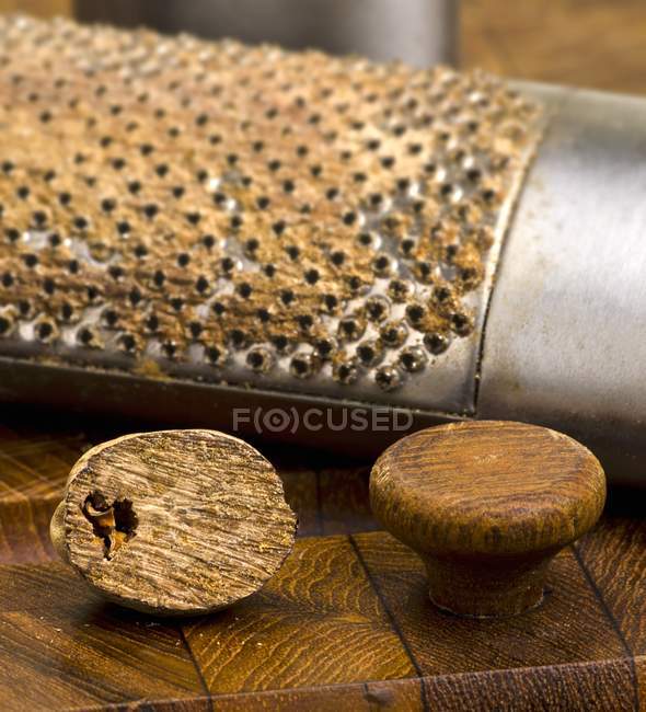 Half of Nutmeg with grater — Stock Photo