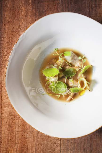 Top view of soup with herbs, preserved mushrooms and langoustine — Stock Photo