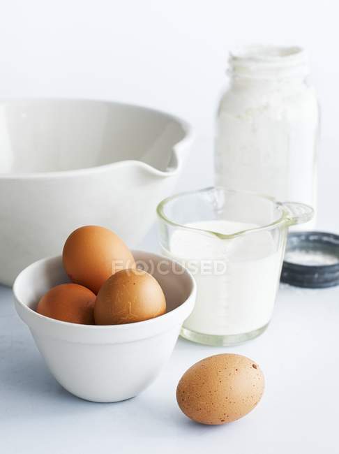 Eggs with milk and mixing bowl — Stock Photo