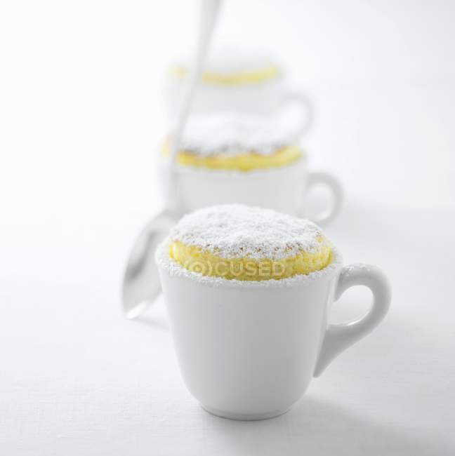 Nahaufnahme von drei Zitronen-Souffles mit Puderzucker in Tassen — Stockfoto