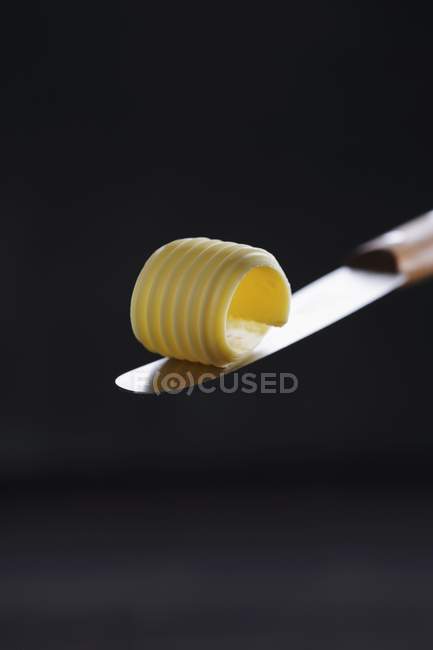 Closeup view of a curl of butter on a knife blade — Stock Photo