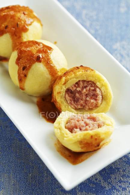Closeup view of sausage meat hash dumplings with goulash sauce — Stock Photo