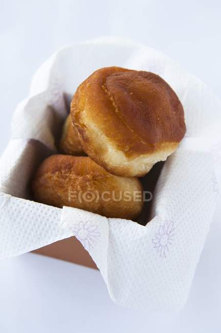 Donuts em caixa com papel — Fotografia de Stock