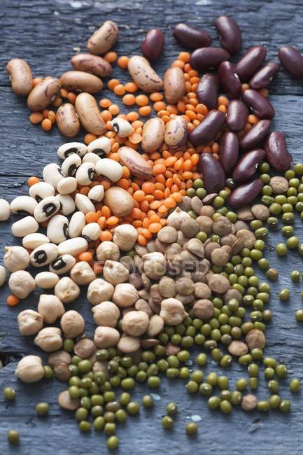Assorted pulses on grey wooden surface — Stock Photo