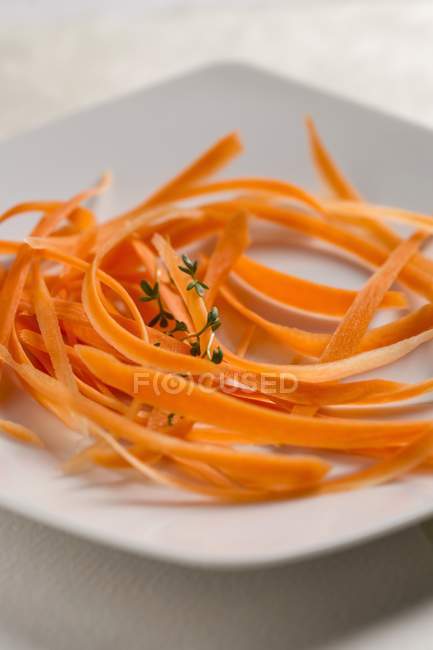 Strisce di carota con timo sul piatto — Foto stock