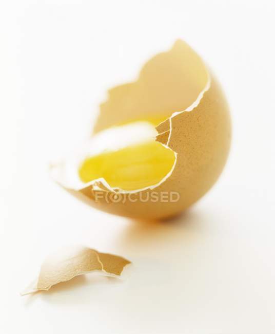 Yema de huevo en cáscara de huevo marrón - foto de stock