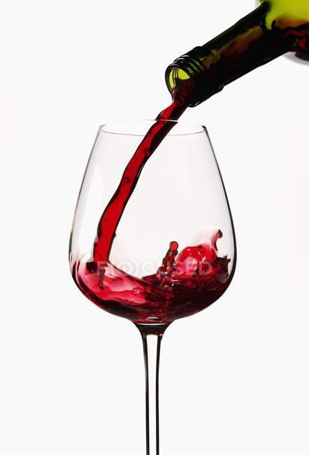 Red wine pouring into glass — Stock Photo