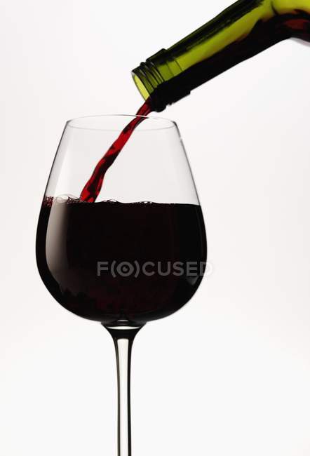 Червоне вино вливається в склянку — стокове фото