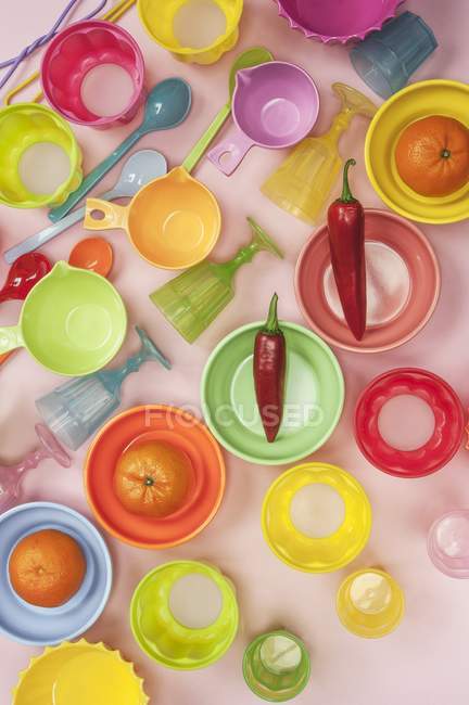 Plastic bowls with tangerines and chillies — Stock Photo