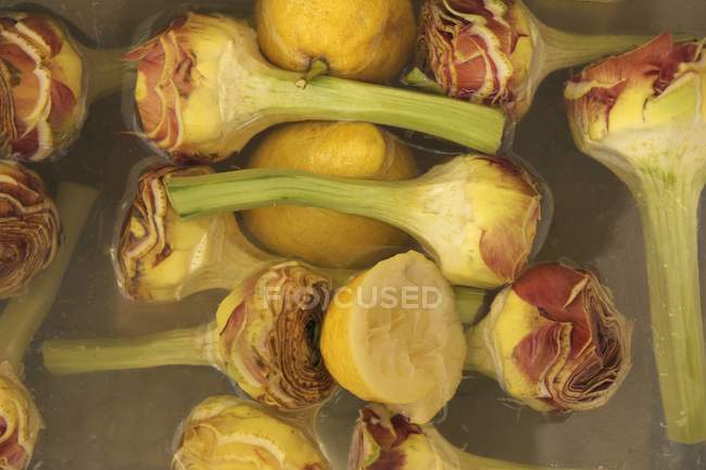 Corações de alcachofra em água de limão — Fotografia de Stock