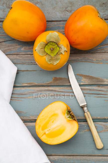 Whole and halved persimions — Stock Photo