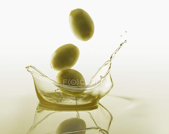 Оливки потрапляють в оливкову олію — стокове фото