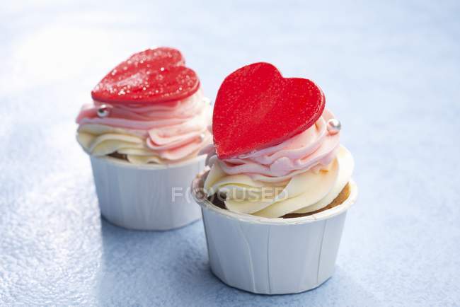 Cupcakes decorated with red hearts — Stock Photo