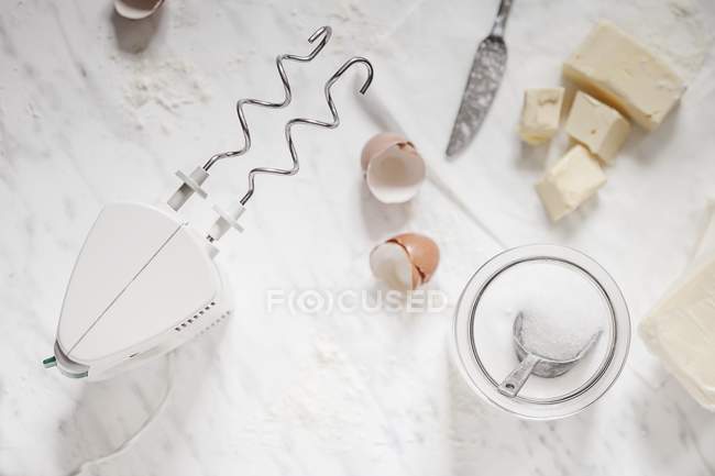 Vista dall'alto degli ingredienti di cottura con miscelatore a mano, zucchero e burro — Foto stock