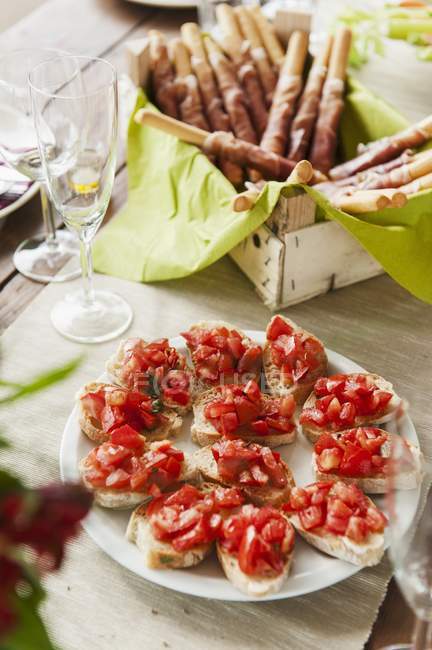 Bruschetta with tomatoes and grissini with Parma ham — Stock Photo