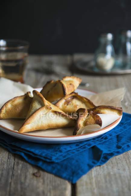 Closeup view of Lebanese pastry parcels on plate and blue folded towel — Stock Photo