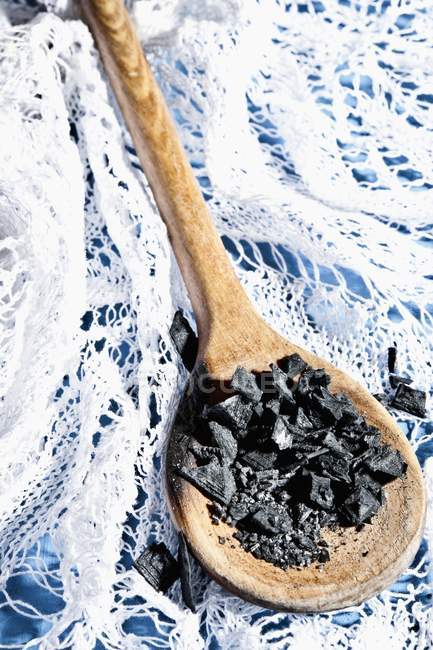 Black sea salt on spoon — Stock Photo