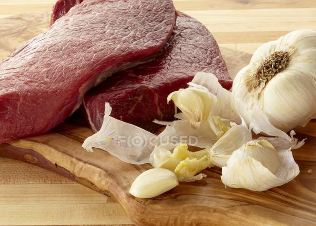 Сырая говядина и чеснок — стоковое фото