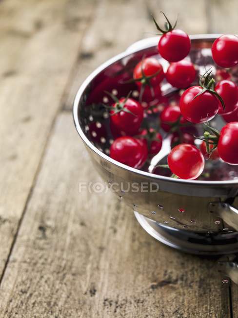 Tomates que caem em escorredor metálico — Fotografia de Stock